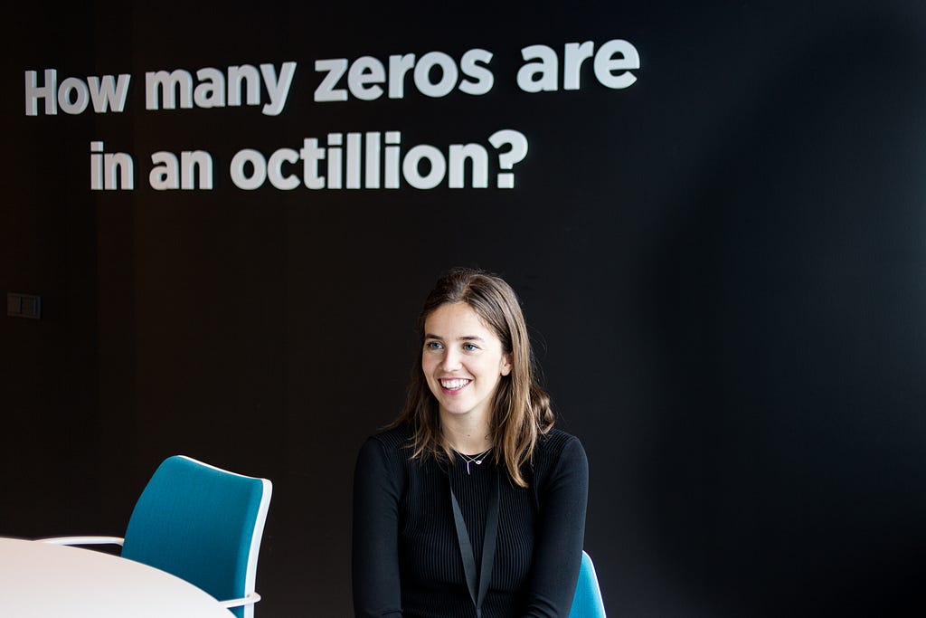 A team member beside a wall asking how many zeros are in an octillion.